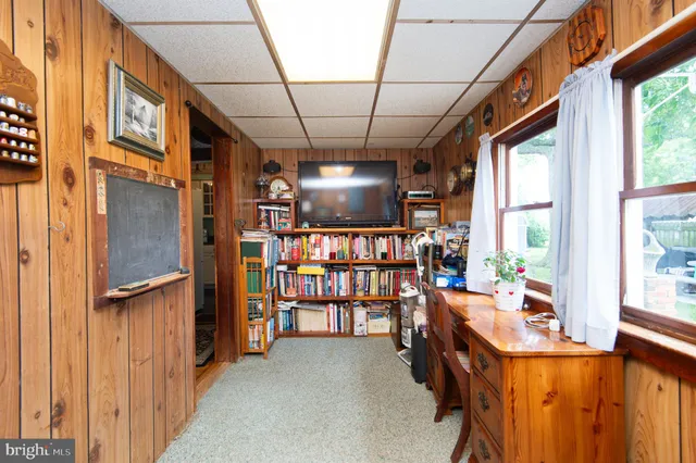 a living room with furniture a desk and chair with windows