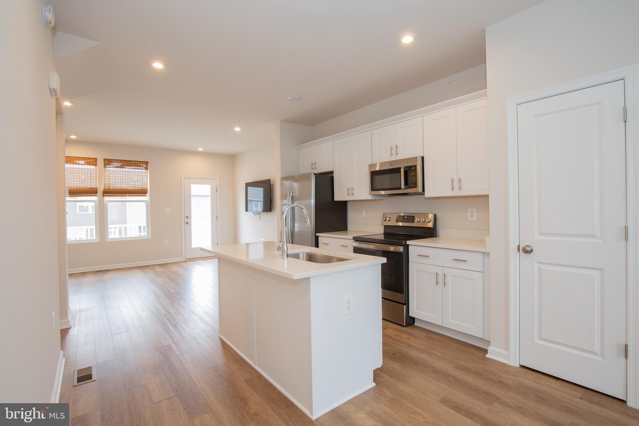 80 Anthem Street Ranson, WV 25438 - Photo 14 of 30 a kitchen with stainless steel appliances granite countertop a stove top oven a sink a refrigerator white cabinets and wooden floor