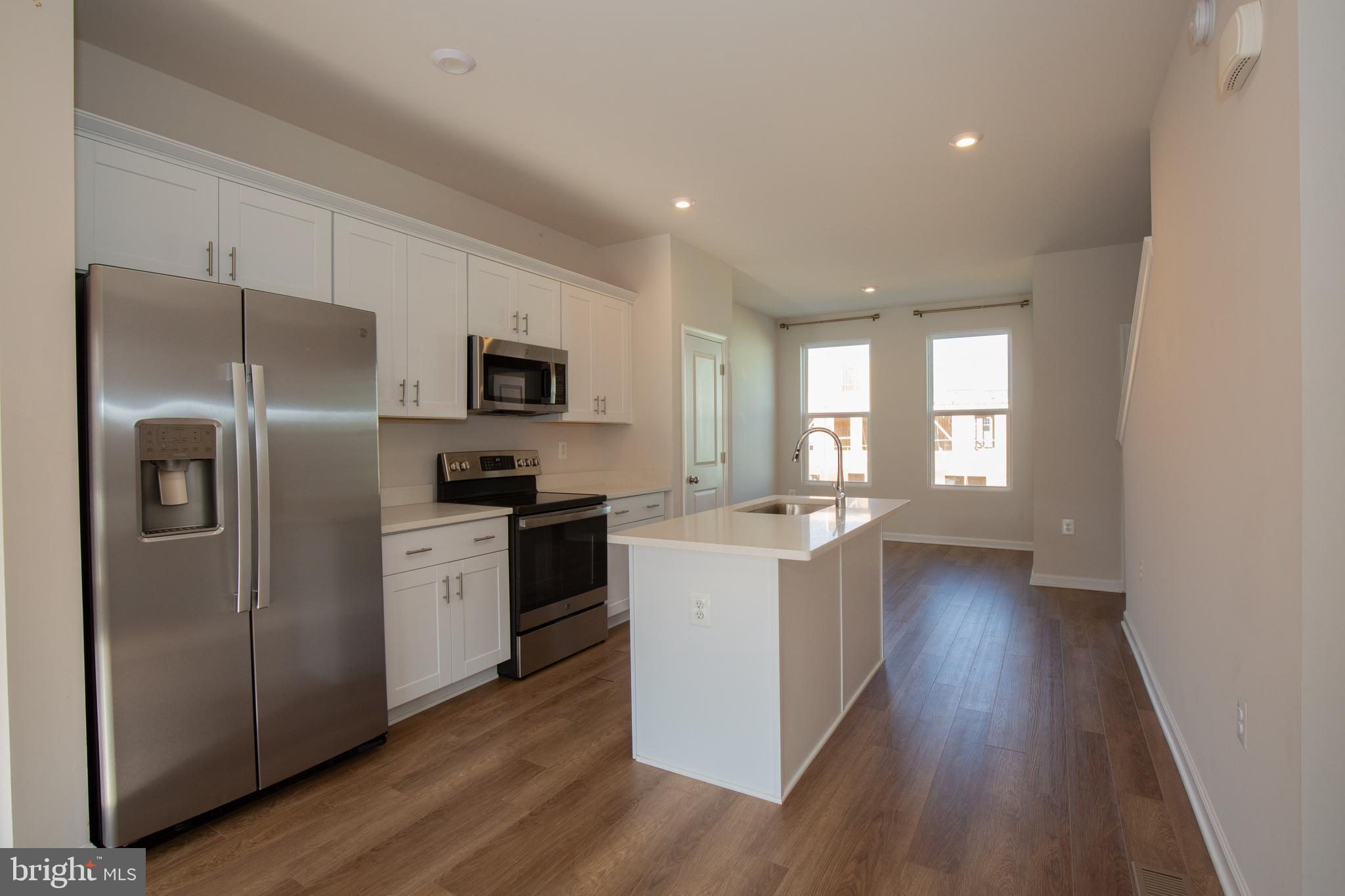 80 Anthem Street Ranson, WV 25438 - Photo 7 of 30 a kitchen with a refrigerator a sink dishwasher a stove and a microwave oven with wooden floor