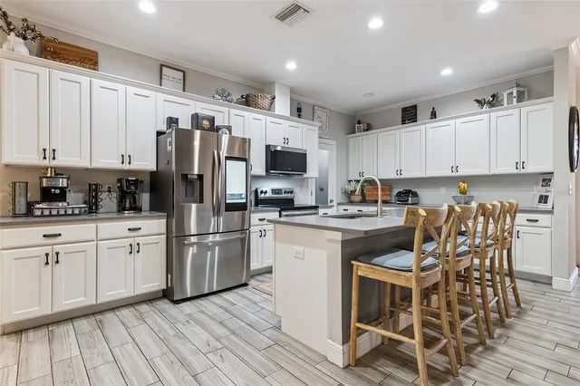 a kitchen with a dining table chairs refrigerator and cabinets