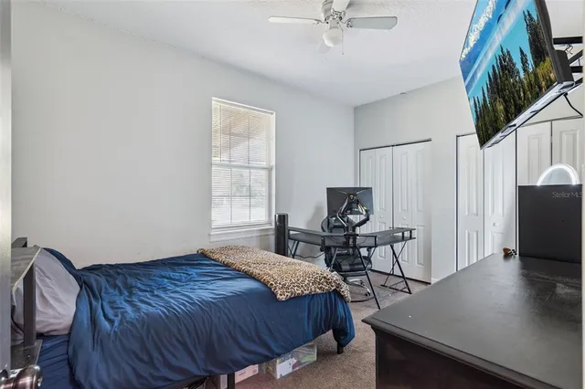 a bedroom with a bed window and a flat screen tv