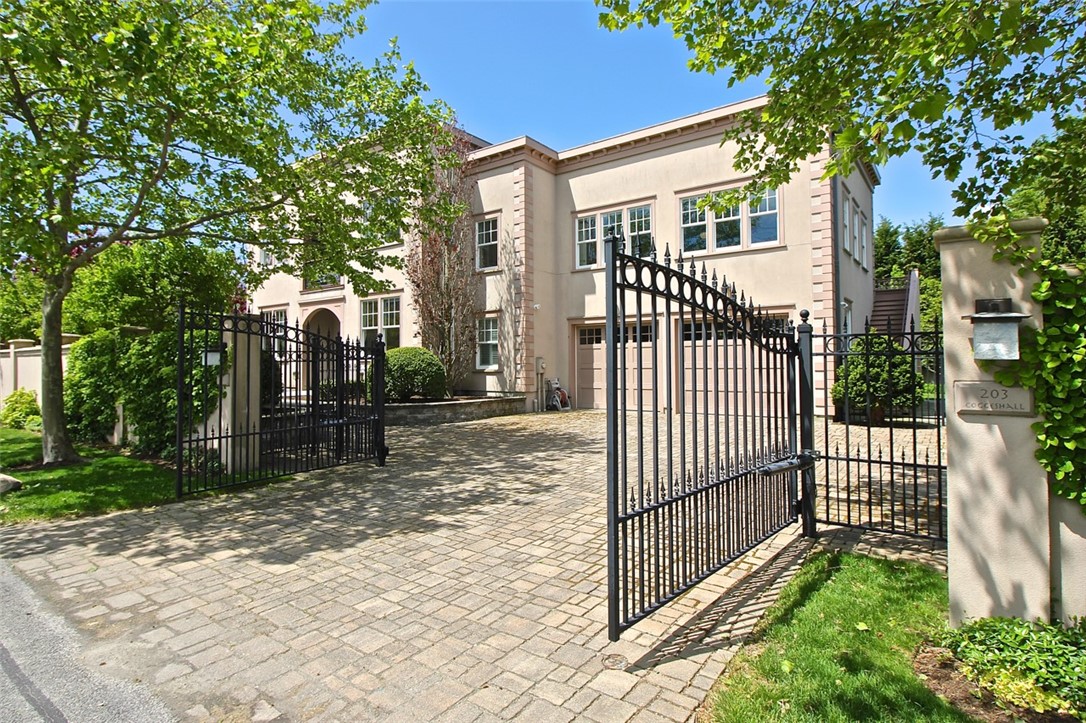 Gated Entry/Front of Property with view to 2 car Garage Stone Driveway & View to Stairway leading to Additional Suite Area