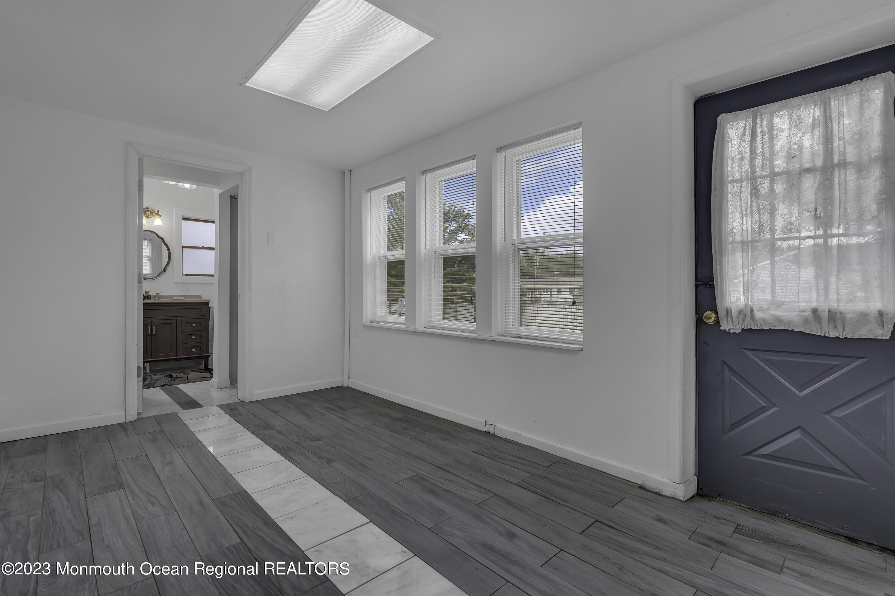 237 Broadway Union Beach, NJ 07735 - Photo 12 of 23 an empty room with wooden floor and windows