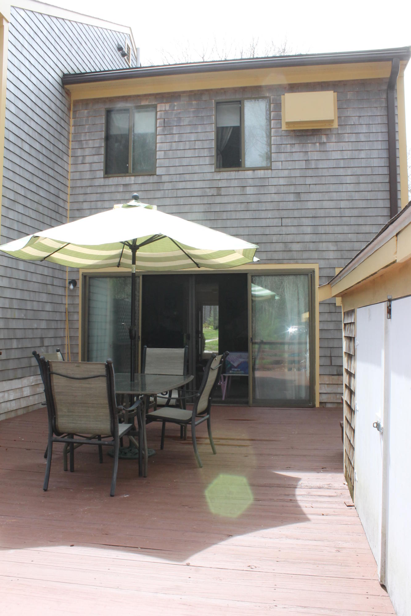 26 Round House Road, Unit 26 Bourne, MA 02532 - Photo 17 of 25 a patio with a table and chairs under an umbrella