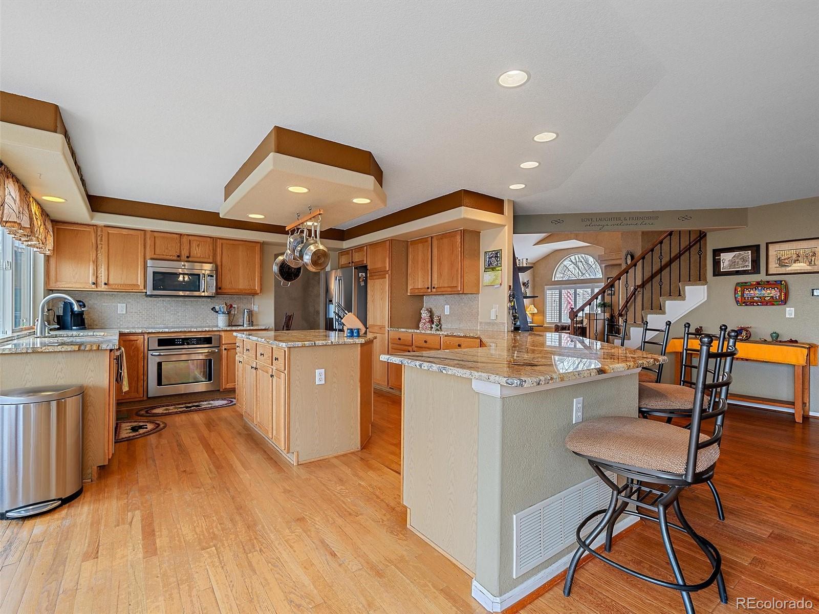 6523 Shannon Trail Highlands Ranch, CO 80130 - Photo 10 of 38 a kitchen view with stainless steel appliances kitchen island granite countertop a sink and cabinets