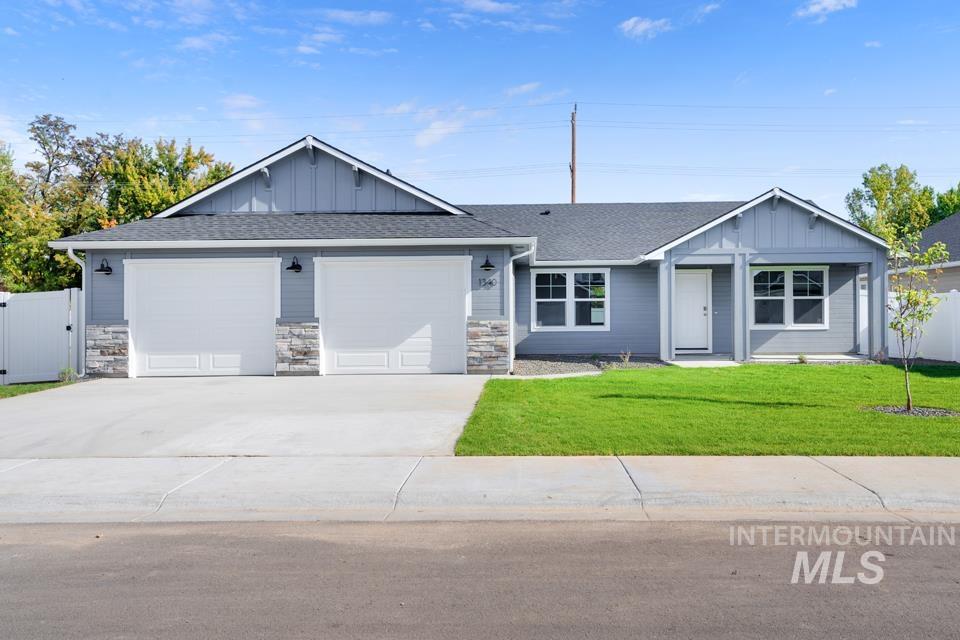 1340 Dawn Street Weiser, ID 83672 - Photo 30 of 32 View of front of home with board and batten siding, roof with shingles, concrete driveway, and a garage
