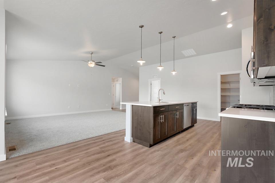 1340 Dawn Street Weiser, ID 83672 - Photo 32 of 32 Kitchen with dark brown cabinets, open floor plan, lofted ceiling, decorative light fixtures, and light wood-style floors
