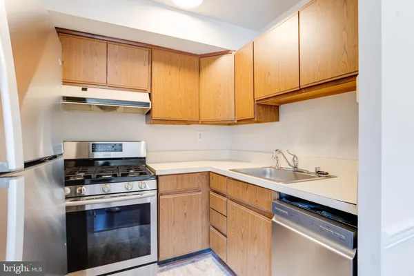a kitchen with stainless steel appliances granite countertop a sink stove and cabinets