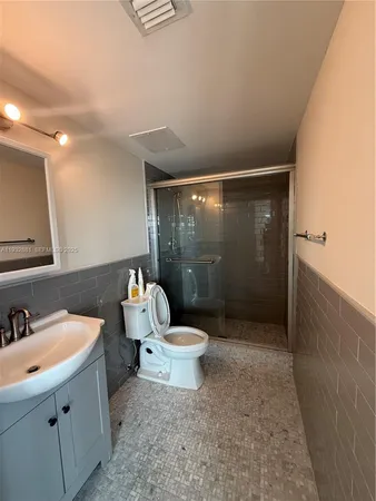 a bathroom with a sink mirror toilet and shower