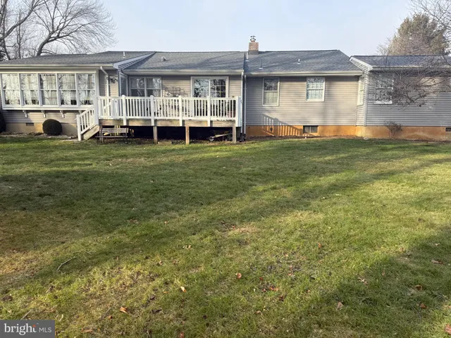 a view of a house with a big yard and large trees