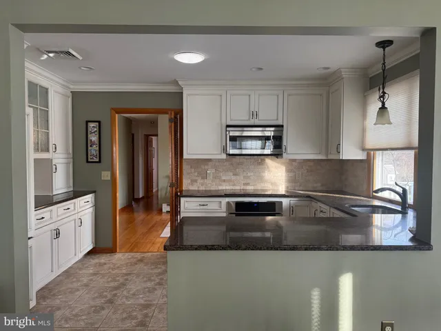 a kitchen with stainless steel appliances granite countertop a sink and a stove top oven