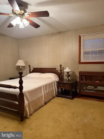 a bedroom with a bed dresser and a chair