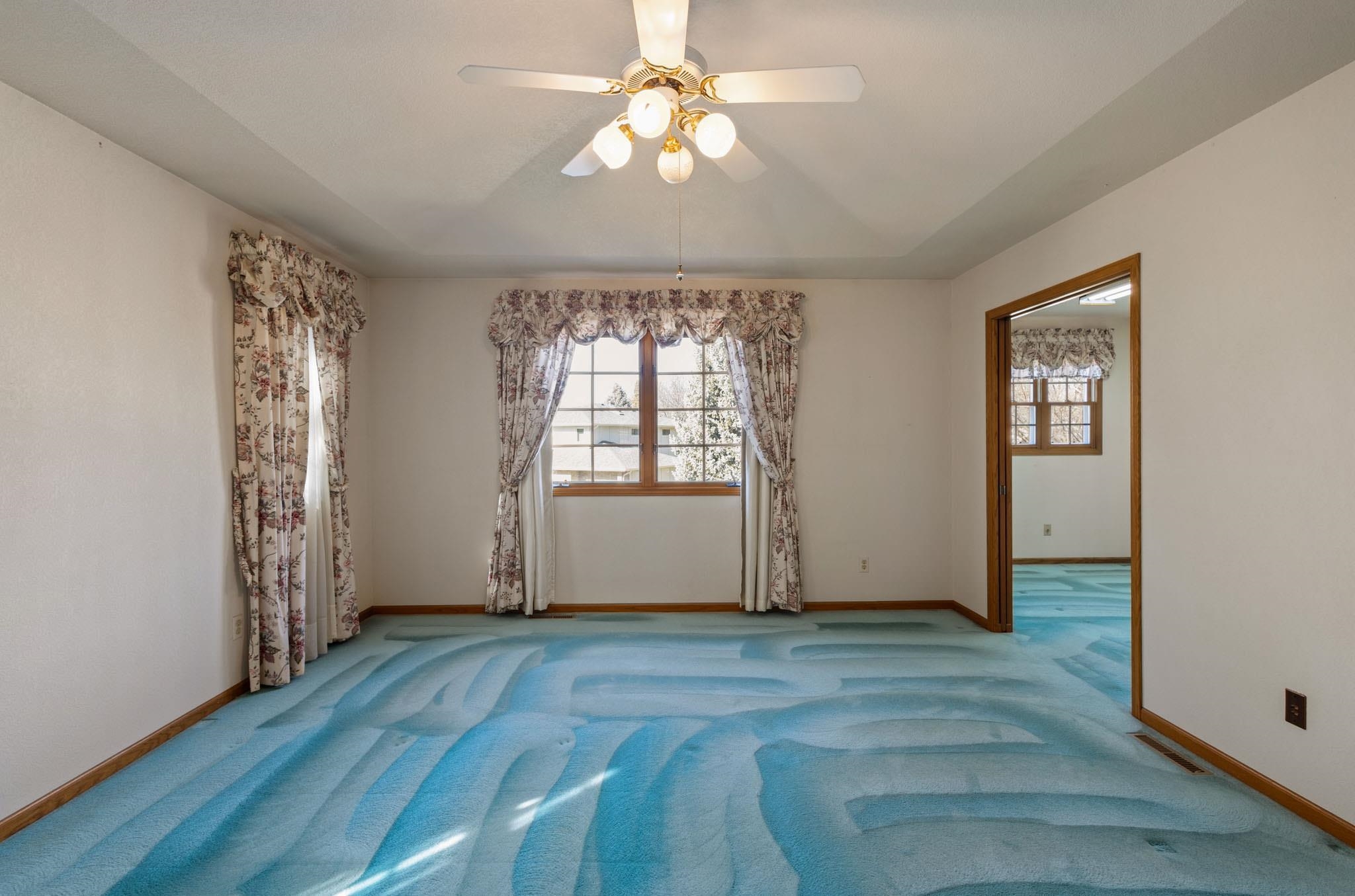 1331 Ruby Way Longmont, CO 80504 - Photo 20 of 42 an empty room with wooden floor chandelier fan and windows
