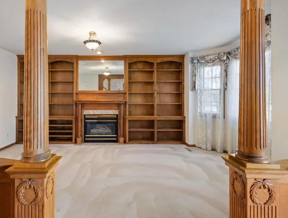 a view of an empty room with a fireplace and a window