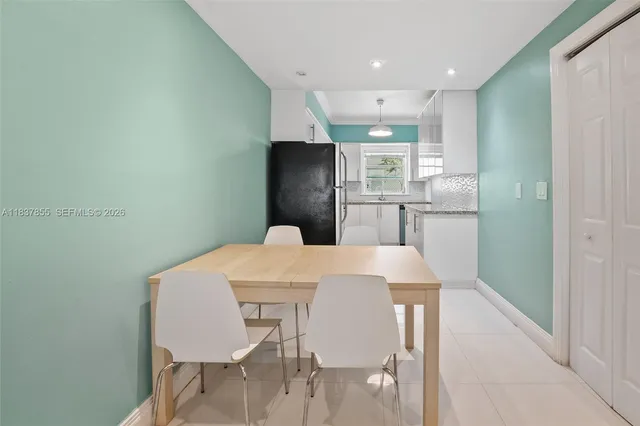 a kitchen with stainless steel appliances a dining table and chairs