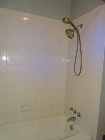 a bathroom with a bath tub with a shower