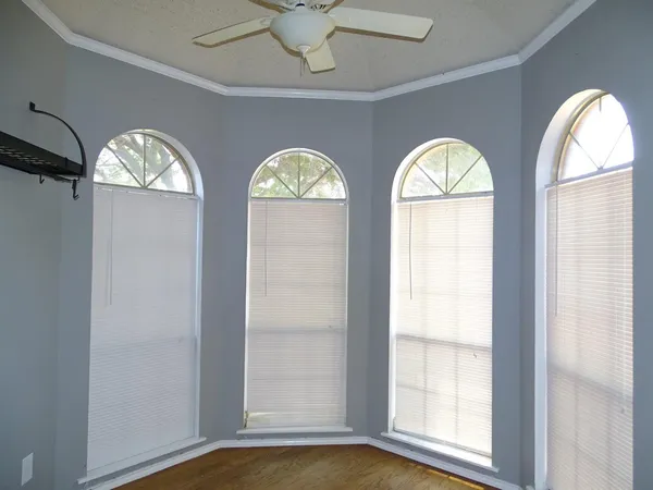 a view of empty room with wooden floor and window