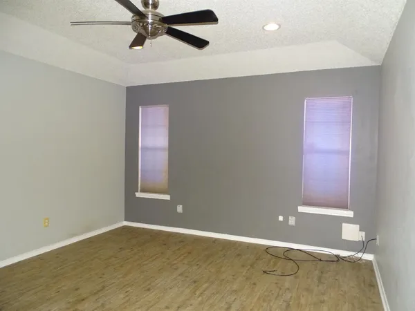 an empty room with closet and fan