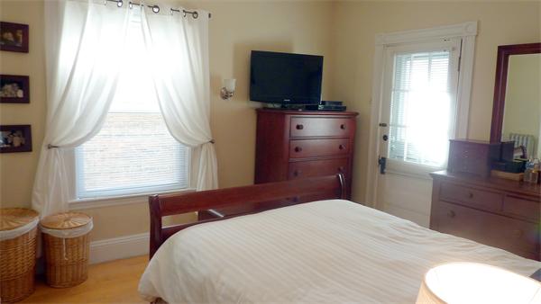 14 Linden Street, Unit 2 Brookline, MA 02445 - Photo 10 of 16 a bedroom with a bed and flat tv screen on the dresser