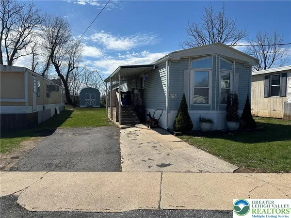 a front view of a house with a yard and garden