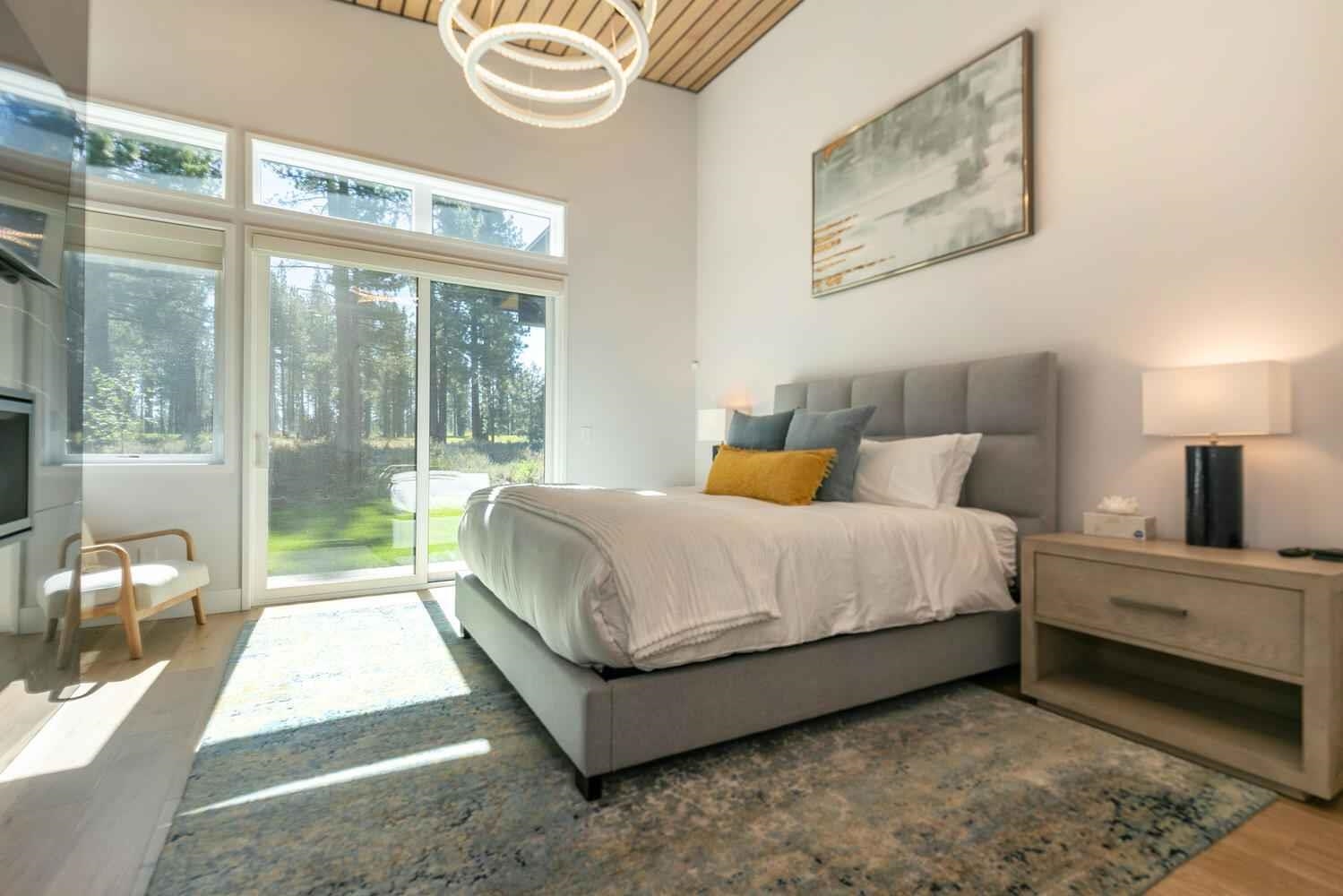 11614 Henness Road Truckee, CA 96161 - Photo 20 of 21 a spacious bedroom with a bed lamp on table and a large window