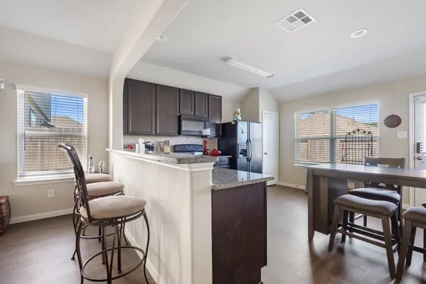 a kitchen with stainless steel appliances granite countertop a refrigerator stove and sink