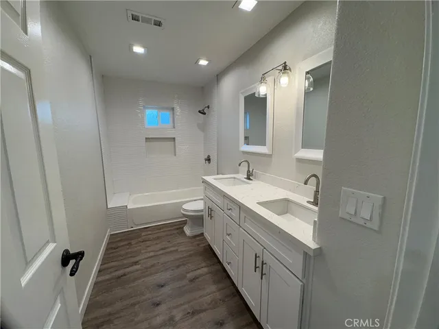 a bathroom with a double vanity sink and mirror with shower