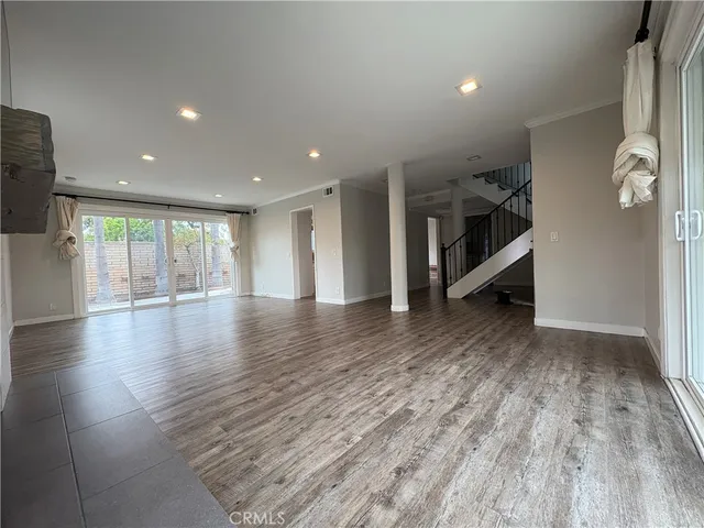 a view of a livingroom with wooden floor and staircase