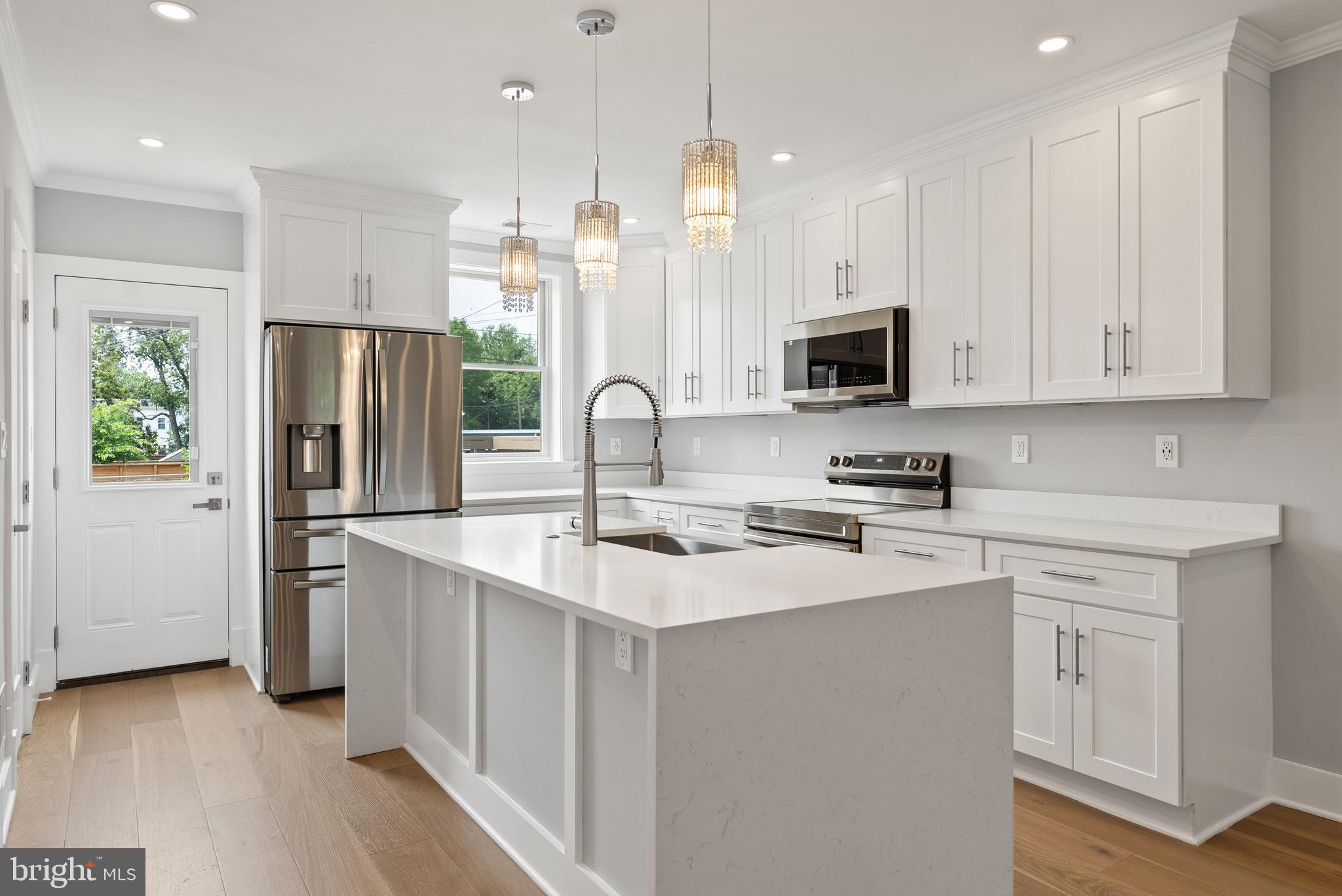 a kitchen with stainless steel appliances a stove refrigerator sink and microwave