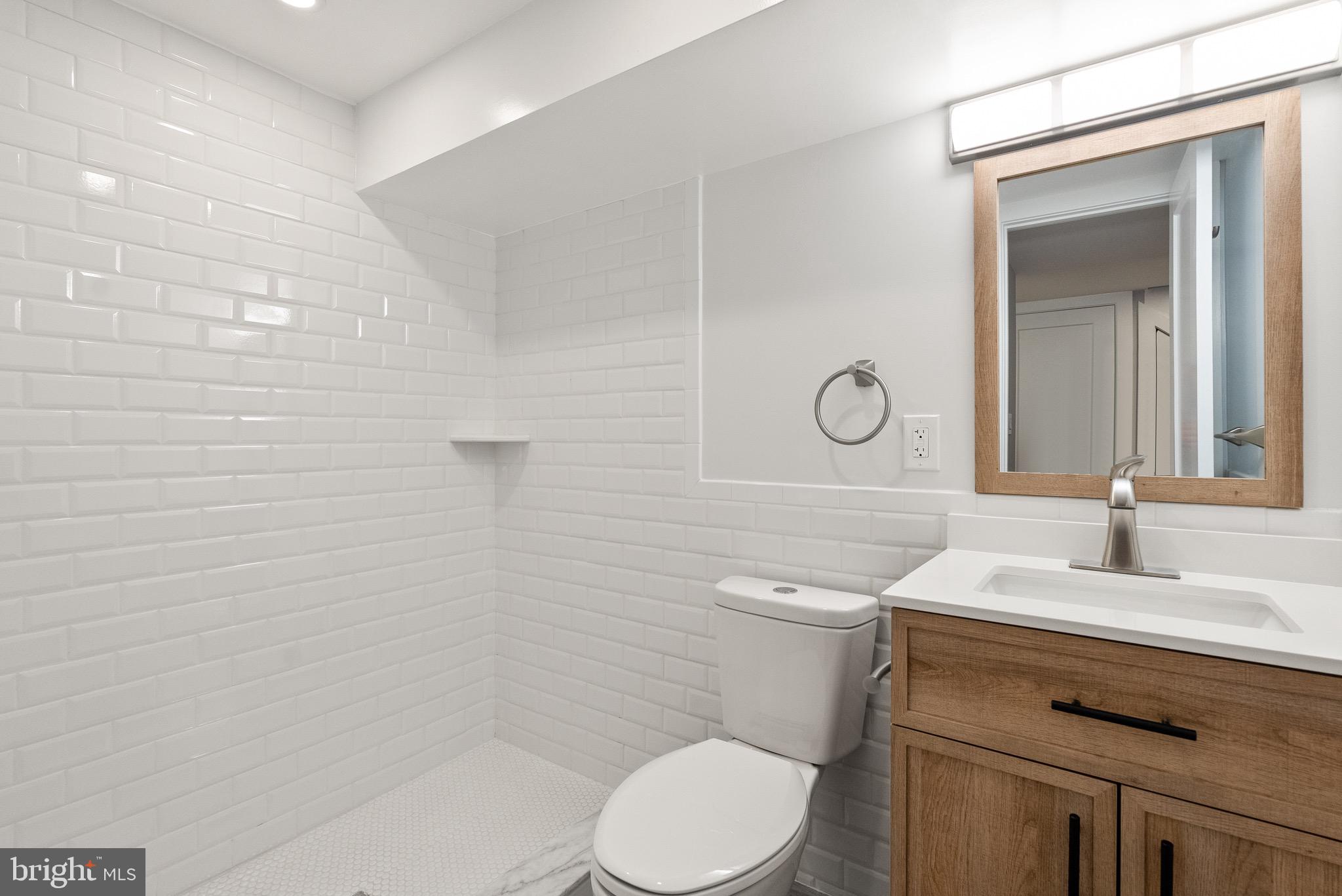 1841 E Street Northeast Washington, DC 20002 - Photo 43 of 50 a bathroom with a toilet sink vanity and mirror