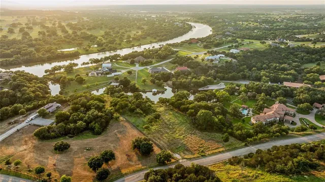 an aerial view of residential houses with outdoor space and trees