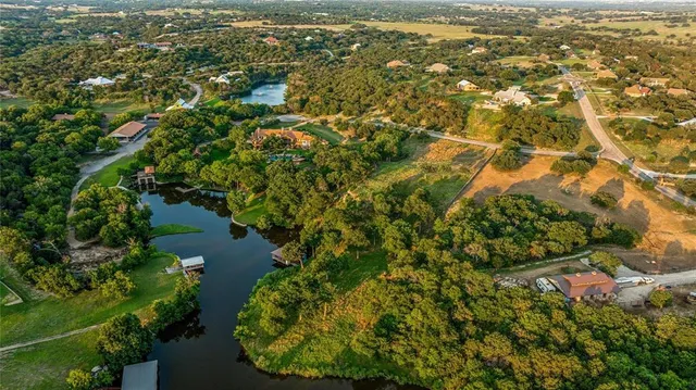 an aerial view of residential houses with outdoor space and trees