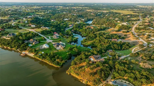 an aerial view of residential houses with outdoor space and trees
