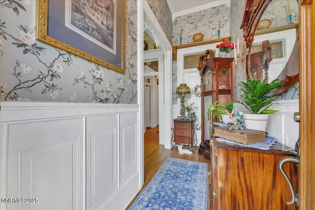 a hallway with painting on the wall and a potted plant