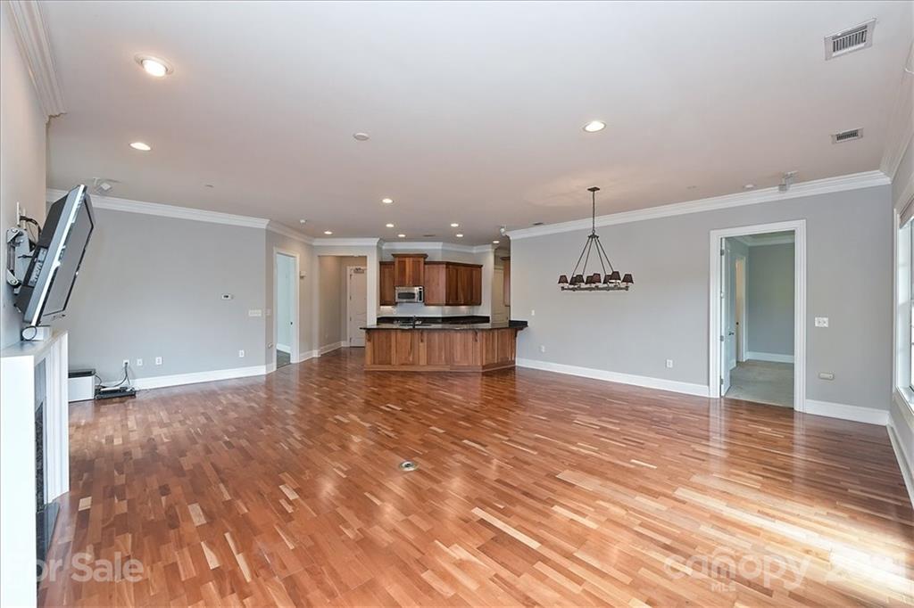 626 Queens Road, Unit 203 Charlotte, NC 28207 - Photo 12 of 48 a view of a kitchen with kitchen island a sink wooden floor and a refrigerator