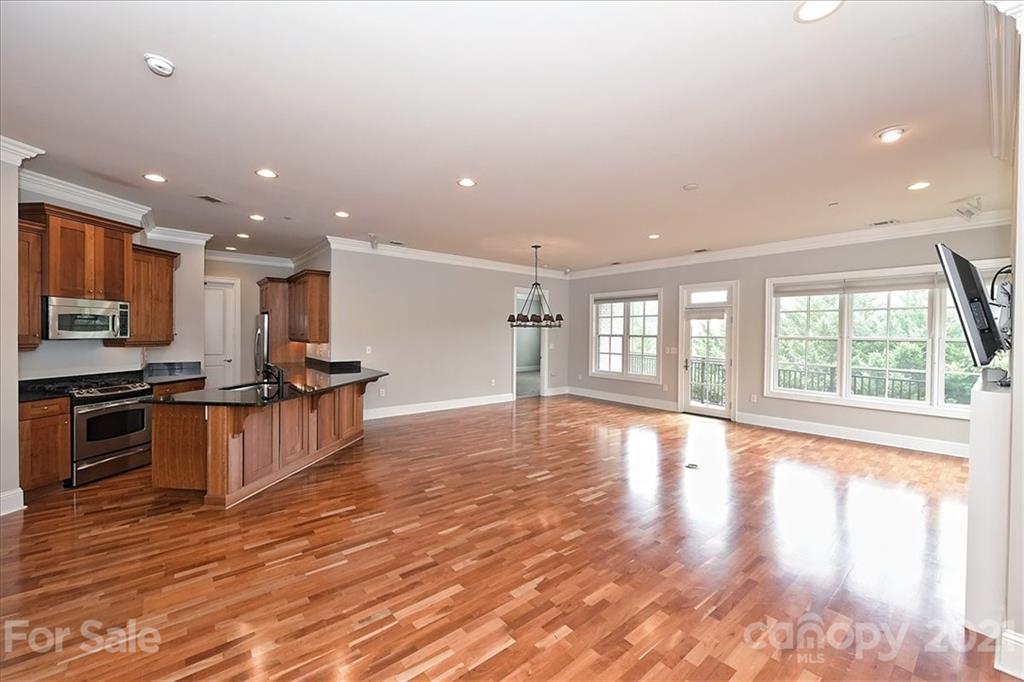 626 Queens Road, Unit 203 Charlotte, NC 28207 - Photo 13 of 48 a view of kitchen with stainless steel appliances granite countertop a stove top oven a sink and a large island with wooden floor
