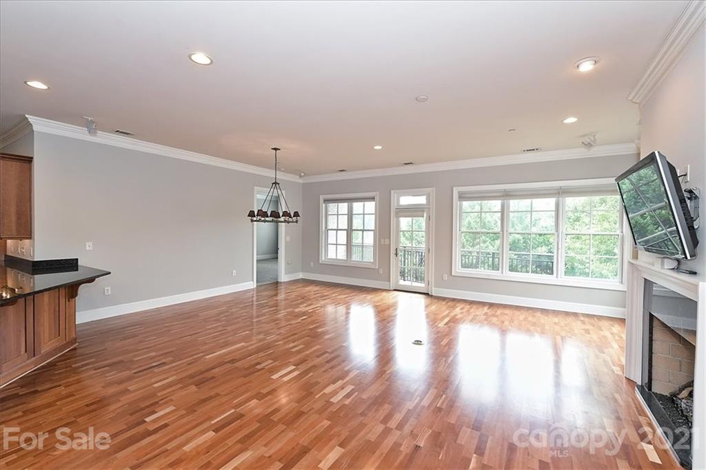 626 Queens Road, Unit 203 Charlotte, NC 28207 - Photo 14 of 48 a view of an empty room with wooden floor and a window
