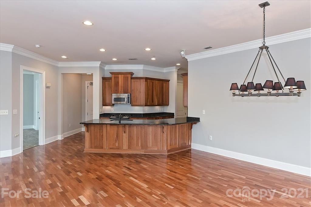 626 Queens Road, Unit 203 Charlotte, NC 28207 - Photo 16 of 48 a view of a room with kitchen island stainless steel appliances wooden floor and window