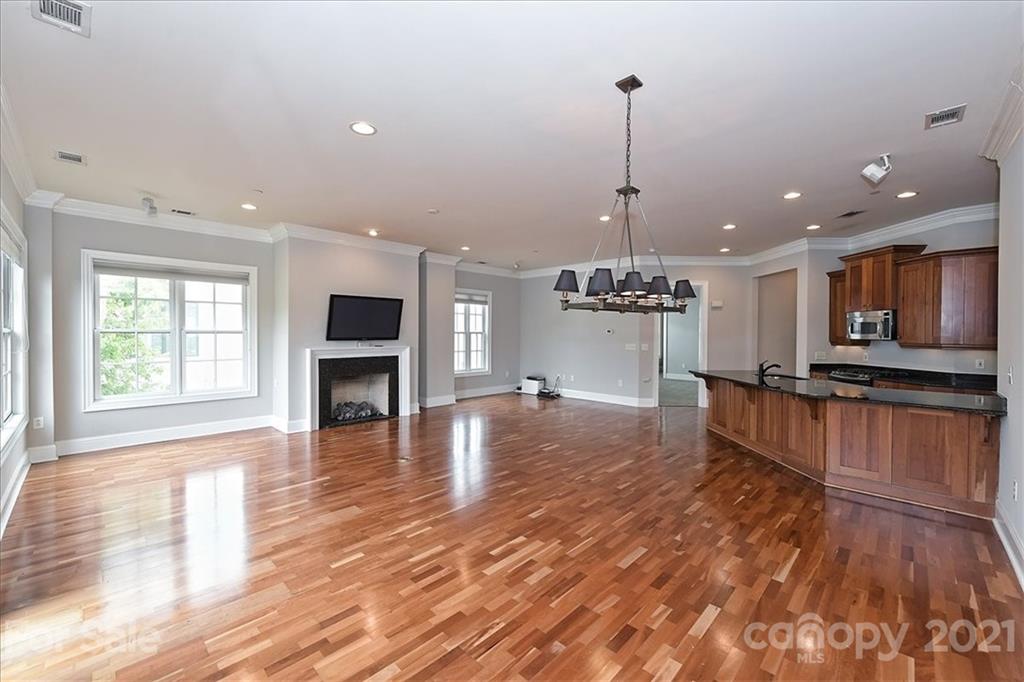 626 Queens Road, Unit 203 Charlotte, NC 28207 - Photo 18 of 48 a view of a living room and kitchen with furniture wooden floor and window