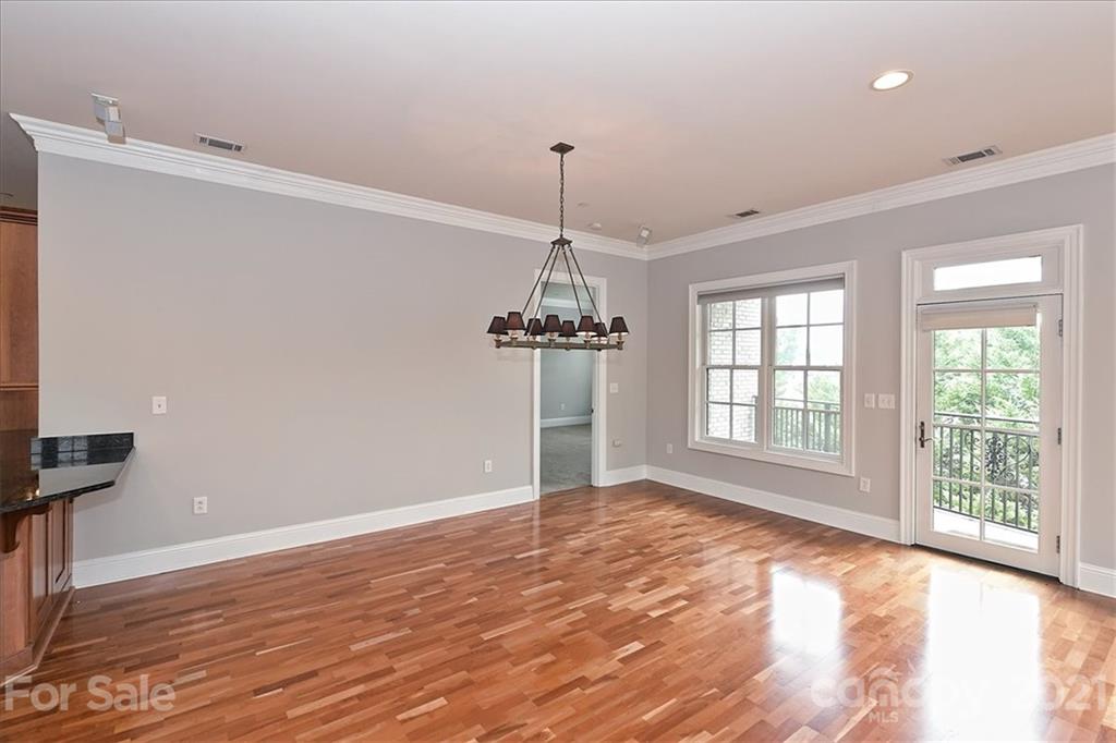 626 Queens Road, Unit 203 Charlotte, NC 28207 - Photo 19 of 48 a view of an empty room with wooden floor and a window