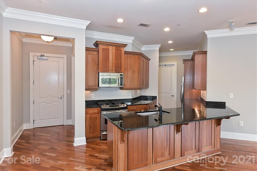 626 Queens Road, Unit 203 Charlotte, NC 28207 - Photo 20 of 48 a kitchen with stainless steel appliances granite countertop a stove a sink and a refrigerator