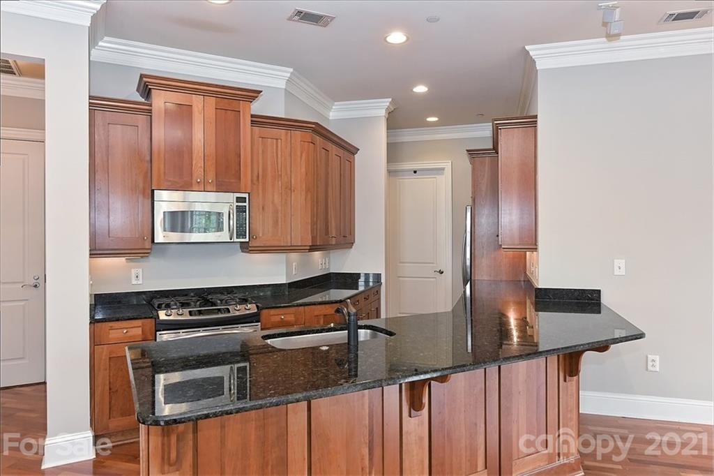 626 Queens Road, Unit 203 Charlotte, NC 28207 - Photo 21 of 48 a kitchen with stainless steel appliances a stove and a refrigerator