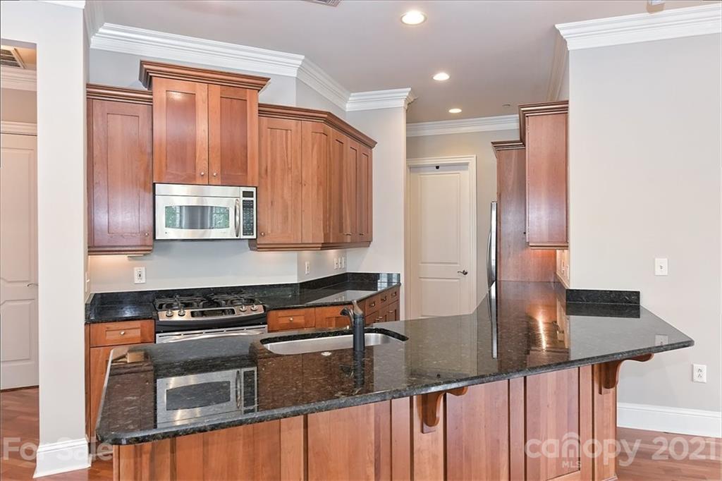 626 Queens Road, Unit 203 Charlotte, NC 28207 - Photo 24 of 48 a kitchen with stainless steel appliances granite countertop a stove a sink and a refrigerator