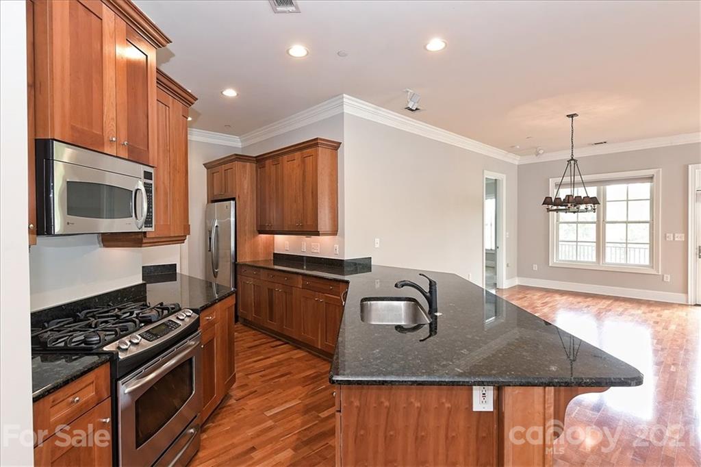 626 Queens Road, Unit 203 Charlotte, NC 28207 - Photo 27 of 48 a kitchen with stainless steel appliances granite countertop a stove a sink and a microwave
