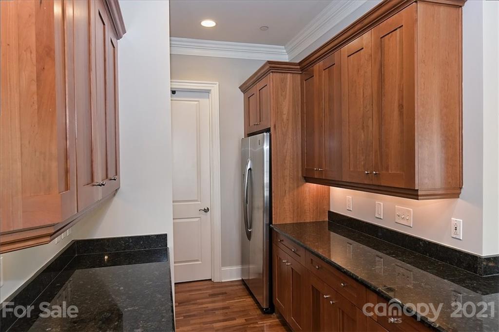 626 Queens Road, Unit 203 Charlotte, NC 28207 - Photo 28 of 48 a kitchen with a refrigerator and cabinets