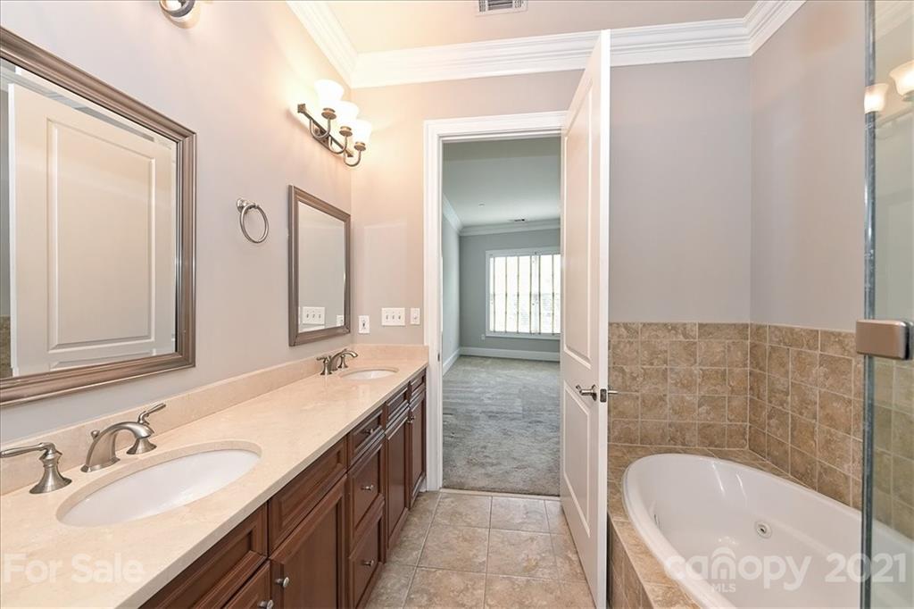 626 Queens Road, Unit 203 Charlotte, NC 28207 - Photo 37 of 48 a bathroom with a tub sink and mirror