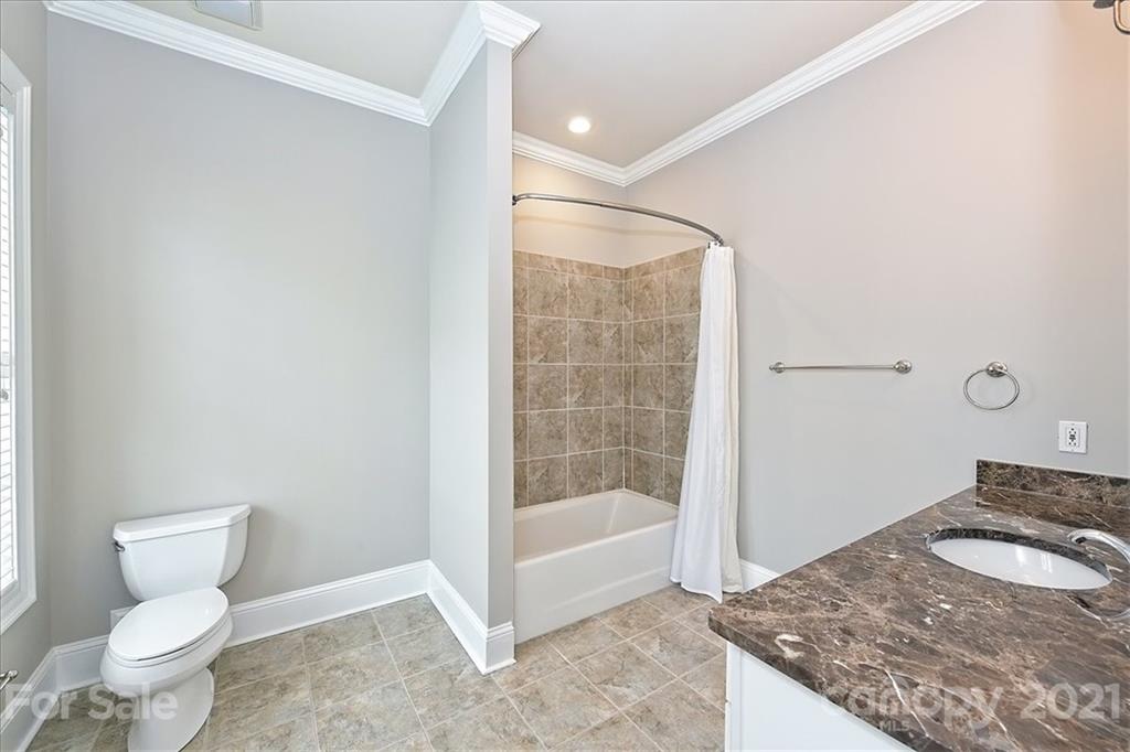 626 Queens Road, Unit 203 Charlotte, NC 28207 - Photo 43 of 48 a bathroom with a granite countertop sink a toilet and shower