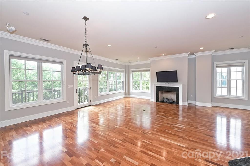 626 Queens Road, Unit 203 Charlotte, NC 28207 - Photo 7 of 48 a view of empty room with wooden floor and fireplace