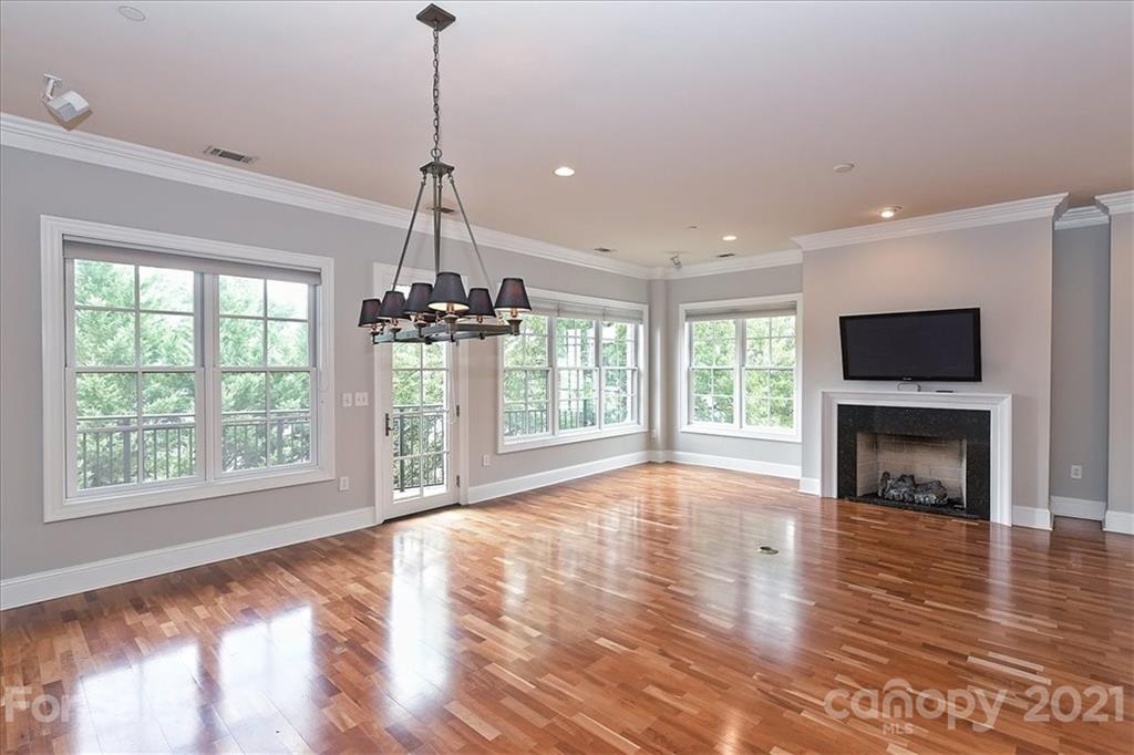 626 Queens Road, Unit 203 Charlotte, NC 28207 - Photo 8 of 48 a view of an empty room with wooden floor fireplace and a window