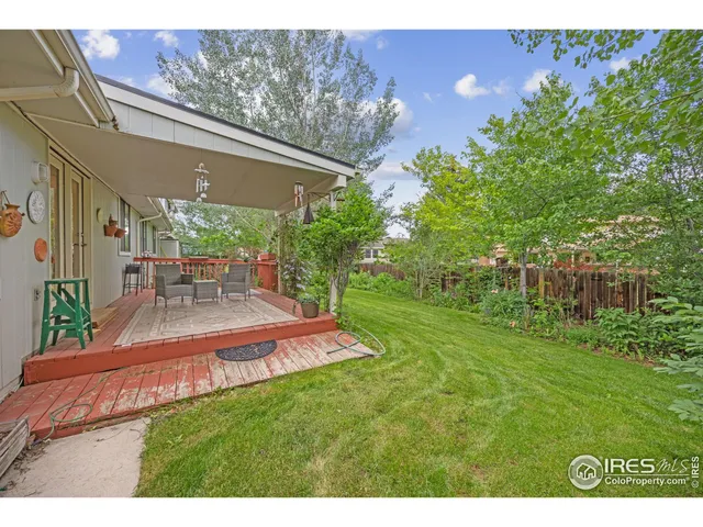 a view of a patio with table and chairs potted plants with floor to ceiling window